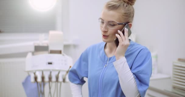 Vrouwelijke arts in gesprek over mobiele telefoon in de gezondheidszorg kliniek — Stockvideo