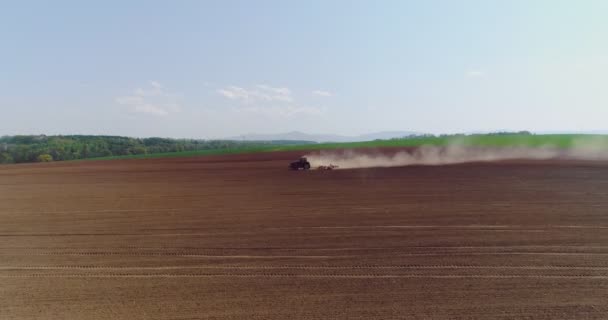 Трактор работает на красивом просторном сельскохозяйственном поле — стоковое видео