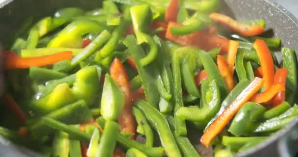 Frying green and red pepper on pan — Stock Video