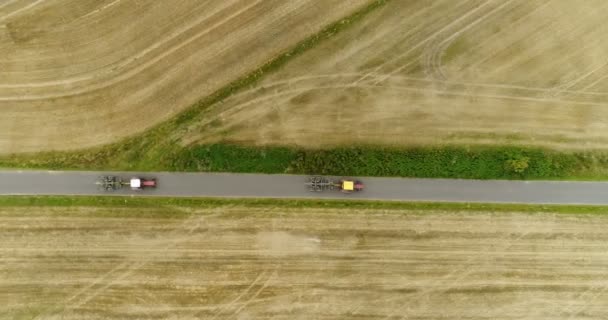 Letecký pohled na silnici projíždějící traktorem. Zemědělský traktor pracující na poli. — Stock video