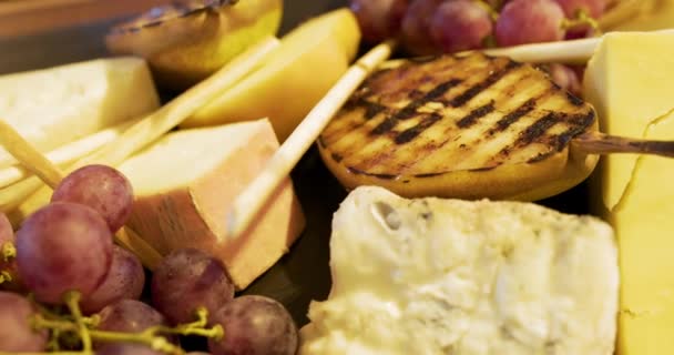 Diferentes tipos de queso sobre tabla de madera en el restaurante — Vídeo de stock