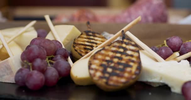 Diferentes tipos de queso sobre tabla de madera en el restaurante — Vídeos de Stock