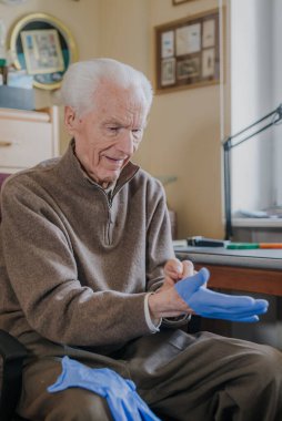 Covid-19 'a karşı koruyucu eldiven giyen yaşlı adam.