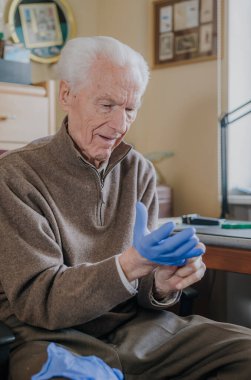 Covid-19 'a karşı koruyucu eldiven giyen yaşlı adam.