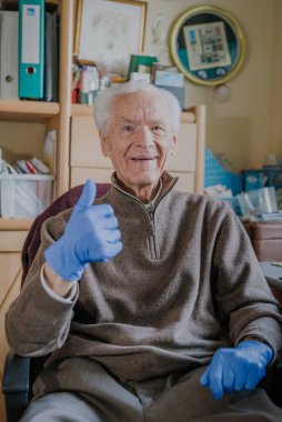 Covid-19 'a karşı koruyucu eldiven giyen yaşlı adam.