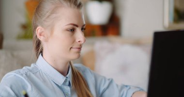 İnternette dizüstü bilgisayarda gülümseyen kadın.