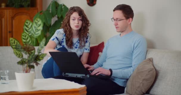 Casal trabalhando juntos em um projeto enquanto o homem está digitando no laptop. — Vídeo de Stock