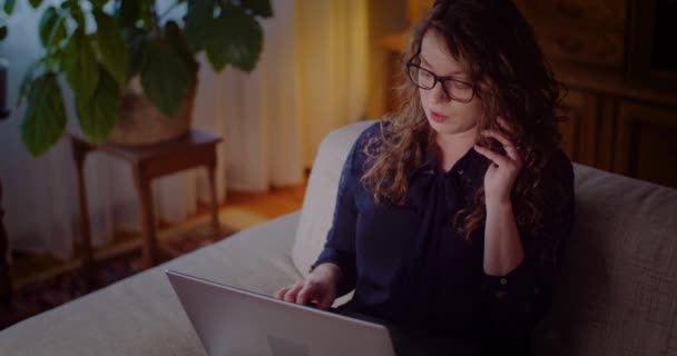 İş kadını portresi cep telefonuyla konuşurken dizüstü bilgisayarda çalışıyor. — Stok video