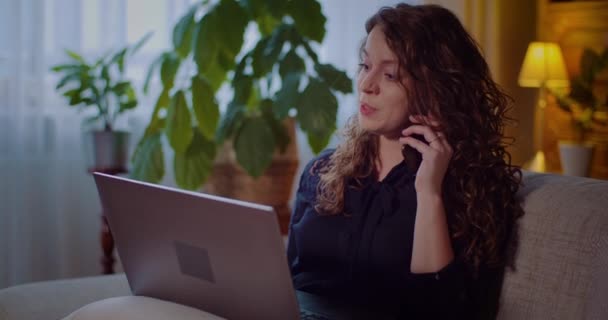 Retrato de la empresaria que trabaja en el ordenador portátil mientras habla en el teléfono móvil. — Vídeo de stock