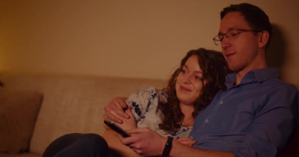 居家看电视的情侣们在客厅的沙发上聊天 — 图库视频影像