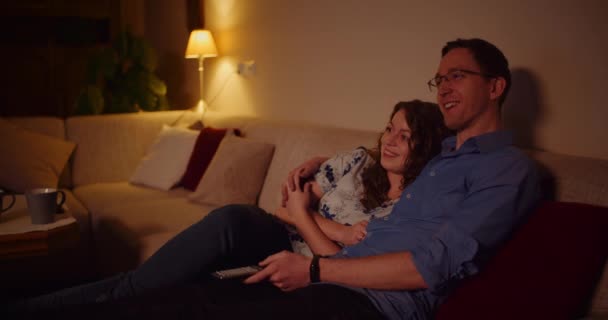 Casal assistindo TV em casa Sentado no Softa na sala de estar — Vídeo de Stock