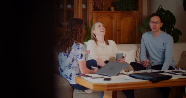 Amigos passam tempo juntos sorrindo e rindo enquanto estão sentados no Softa em casa. — Vídeo de Stock