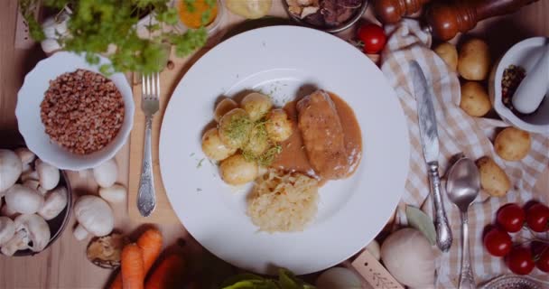 Mahlzeit im Teller inmitten verschiedener Zutaten auf einem Holztisch — Stockvideo