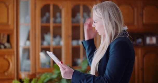 Two women discussing a tablet display while one woman is also talking on a smartphone — Stock Video