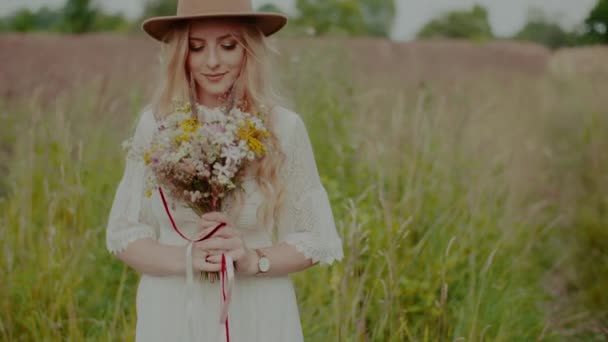 Smiling Boho Hippie Girl Holding Flowers Outdoors — Vídeo de stock