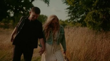 Affectionate Hipsters Walking and Smiling in Summer at Sunset