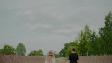 Kız sevgilisine sarılıyor bir buket kır çiçeği tutuyor