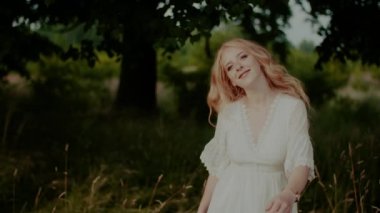 Kaygısız Boho Kadını yazın çayırda yürüyor ve gülümsüyor.