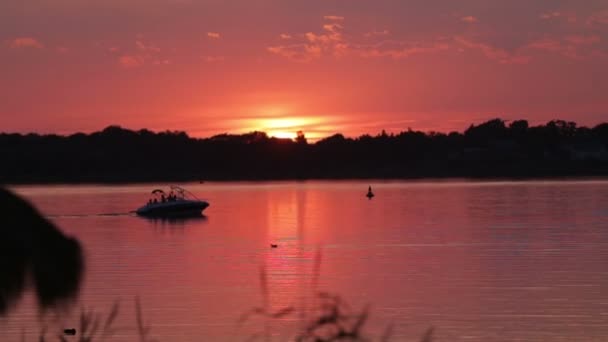 Barca cu motor se deplasează pe lac în timpul apusului — Videoclip de stoc