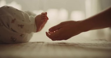 A touching moment of a mother gently touching the feet of her newborn son, symbolizing the bond and tenderness of motherhood.