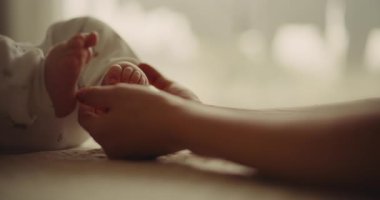 Emotionally touching moment as a mother holds her newborn sons feet, symbolizing motherhood and emotional bonding.