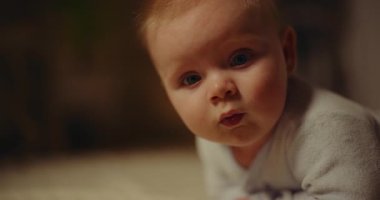 A close-up portrait of a newborn baby boy with a smiling face. Strong focus on the babys expression and features.