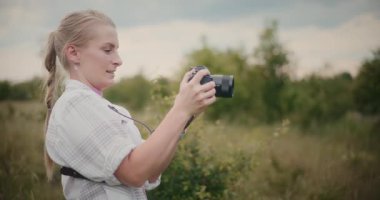 Güzel bir sonbahar manzarası arasında DSLR kamerasıyla fotoğraf çeken bir fotoğrafçının yakın çekim görüntüleri..