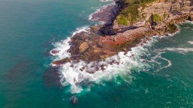 Sydney, Avustralya 'nın kuzey sahillerindeki Turimetta Head' in hava manzarası güneşli bir günde dalgalarla karaya vurdu.