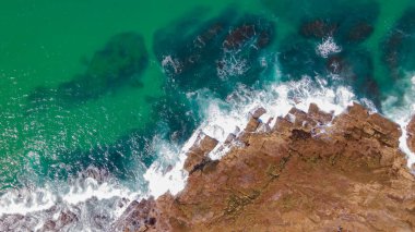 Sydney 'nin kuzey sahillerindeki Narrabeen kaya havuzunun yakınındaki kayaları yıkayan sörf.