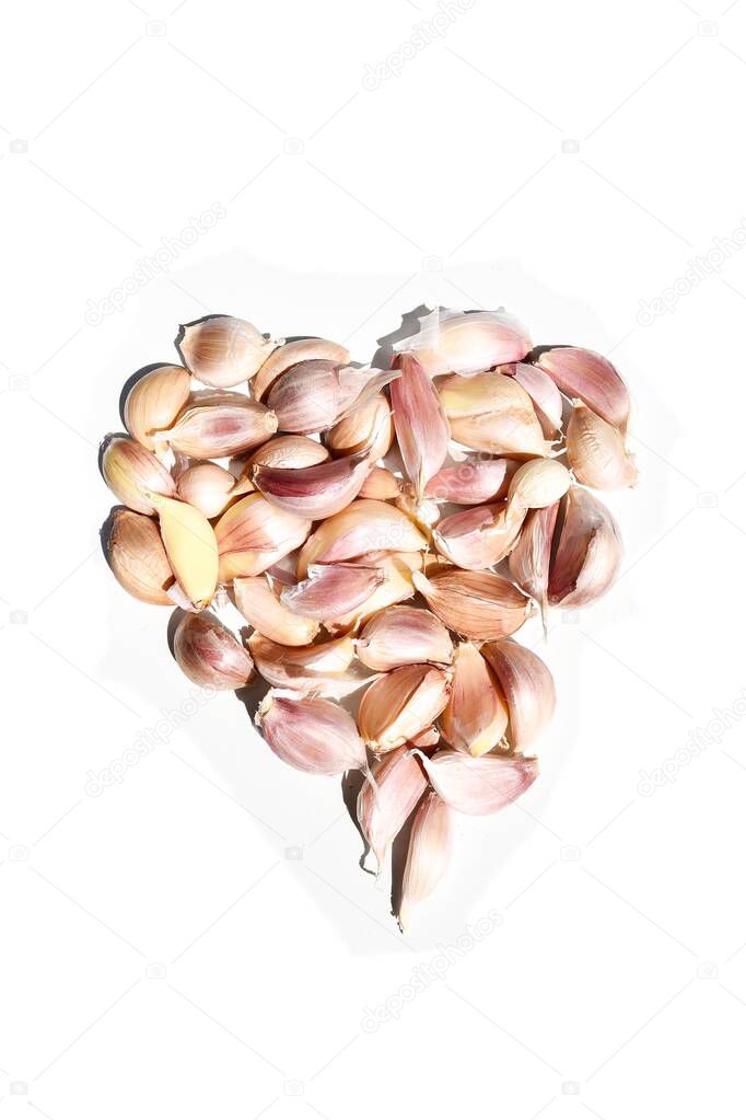 Lots of Garlic cloves are arranged as a heart-shaped, Spices and herbs are spicy on white background