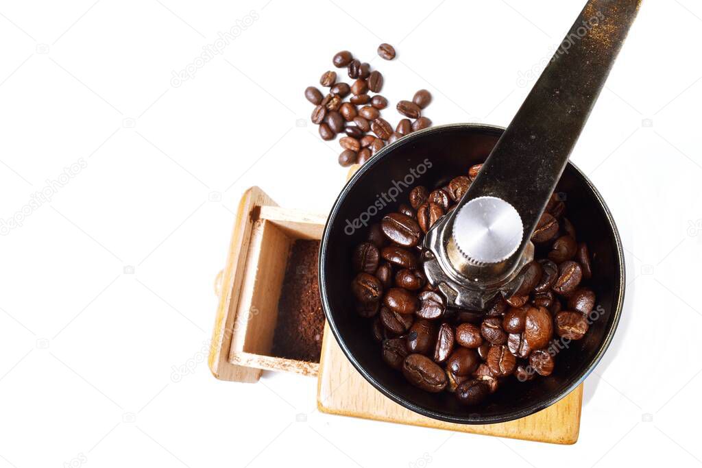 Coffee powder in open drawer of manual coffee grinder on white background