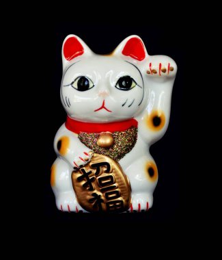 Japon şanslı kedisi ya da Japon karakterli Maneki Neko siyah arka planda altın madalya konusunda iyi şanslar ve servet demektir.