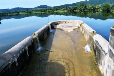 Barajdaki su taşar taşar, bataklık dağları, ormanları, Tayland 'ı yansıtır.