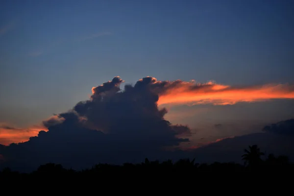 黄昏时分 乌云在蓝天的夕阳西下 地平线在热带地区开始泛起紫色的橙色 云彩像巨大的生物喷火 — 图库照片