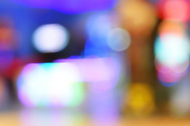 Tatil sezonunun kutlanması için gece lambası arka planda kalıyor. Renkli ışık daireleri mavi üzerine yayılıyor. Kapalı alandan gelen sarı ve kırmızı ışıklarla.