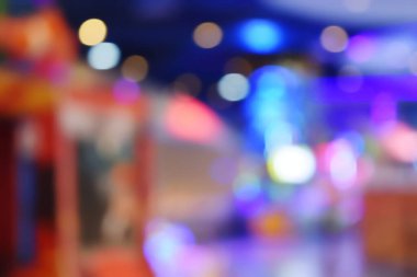 Tatil sezonunun kutlanması için gece lambası arka planda kalıyor. Renkli ışık daireleri mavi üzerine yayılıyor. Kapalı alandan gelen sarı ve kırmızı ışıklarla.