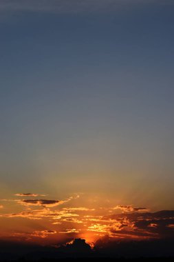 Gün batımında mavi gökyüzünde güneş ışığı ile kümülüs bulutu, ufuk turuncu ve altın rengine dönüşür gece, yumuşak bulutlar Tayland tropikal kuşağında