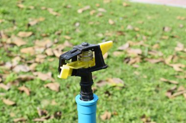 Arka planda yeşil çimenler olan su fıskiyelerini kapatın.