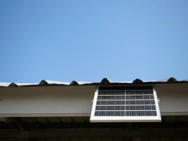 Arka planda mavi gökyüzü olan küçük taşınabilir güneş pili paneli, Tayland 'da alternatif teknoloji kullanarak evdeki elektrik üretimi için temiz enerji.