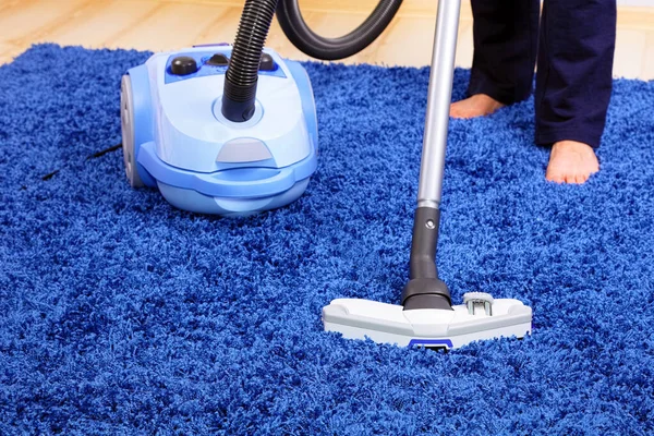 Powelful vacuum cleaner in action-a men cleaner a carpet.