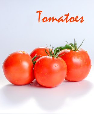 Beyaz arka planda yeşil yapraklı taze domatesler.