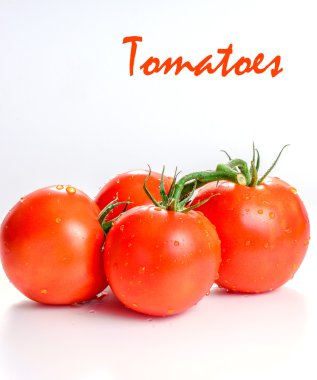 Beyaz arka planda yeşil yapraklı taze domatesler.