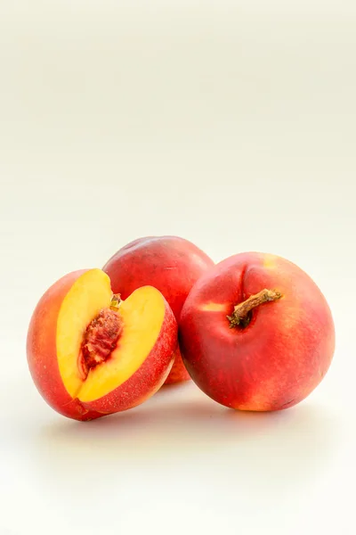 Свежие персики на белом фоне — стоковое фото