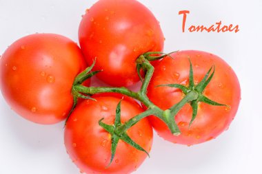 Beyaz arka planda yeşil yapraklı taze domatesler.