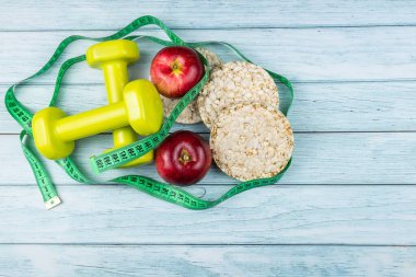 Diyet planı, halterler ve diyet yemekleri arka planda taze meyveler, kilo kaybı ve diyet konsepti,