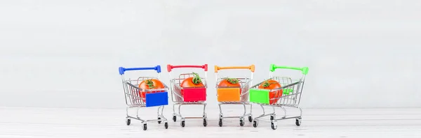 Shot of ripe tasty tomatoes in shopping cart or trolley on white background. Tomato trading concept. Online shopping concept. Banner size. Copy space.
