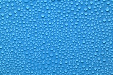 Yüzey su damlacıklarıyla doluydu. Mavi arkaplanda Seçici odak