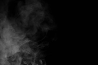 Nemlendiriciden püskürtülmüş beyaz su buharının yakın görüntüsü. Siyah arkaplanda izole