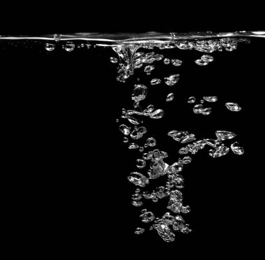 Köpüklü soda ve beyaz oksijen havası, su yüzeyinde kabarcıklar akan temiz su altında, siyah bir zemin üzerinde.