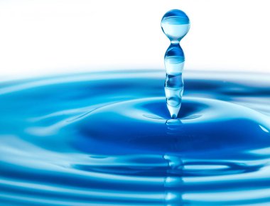 Koyu mavi su damlacıkları su yüzeyine sıçrıyor. Mükemmel bir su dalgası yaratıyor.